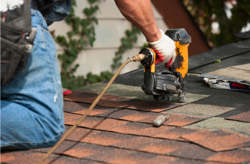 Roofer working on an older Tulsa home's shingle roof